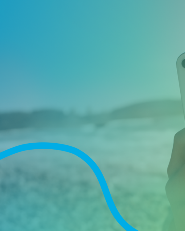 Kille med en mobil på en strand