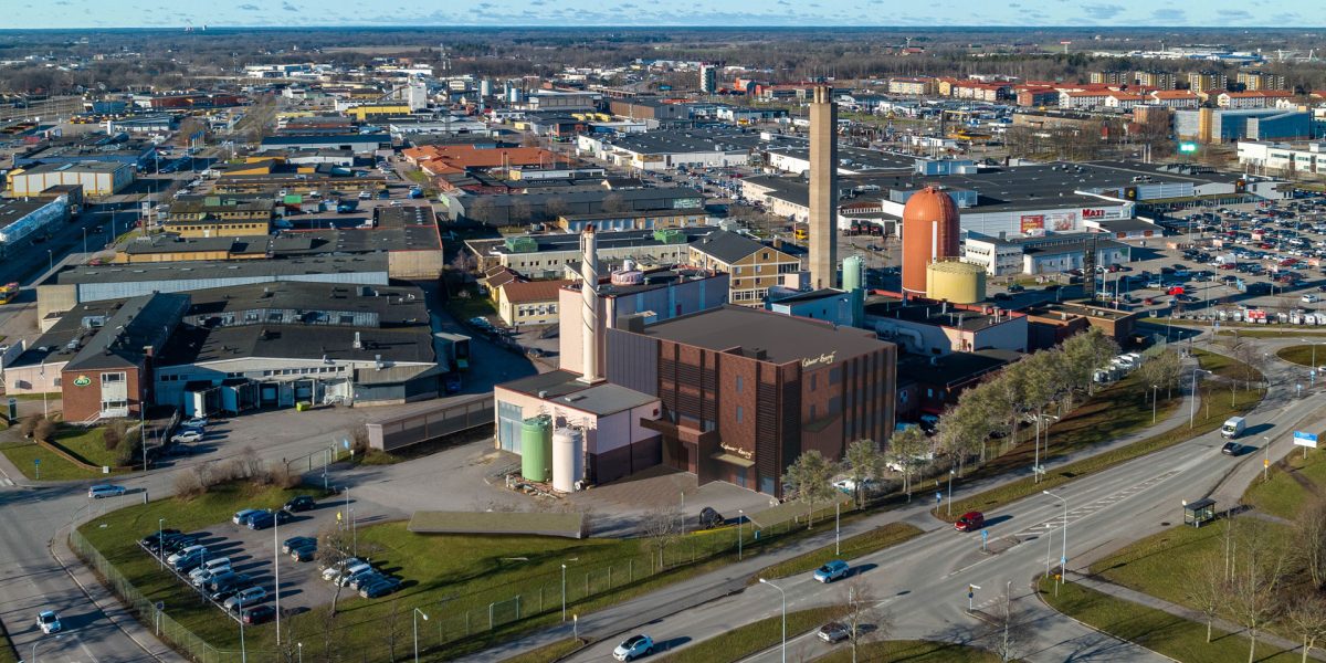 Flygbild över gamla industriområdet med en rendering av Kalmar Energis nya kontorsdel vid fjärrvärmeverket Draken.