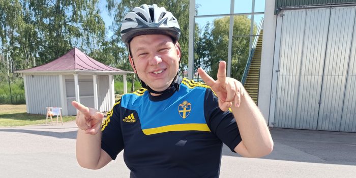 Kille med cykelhjälm som gör segertecknet.
