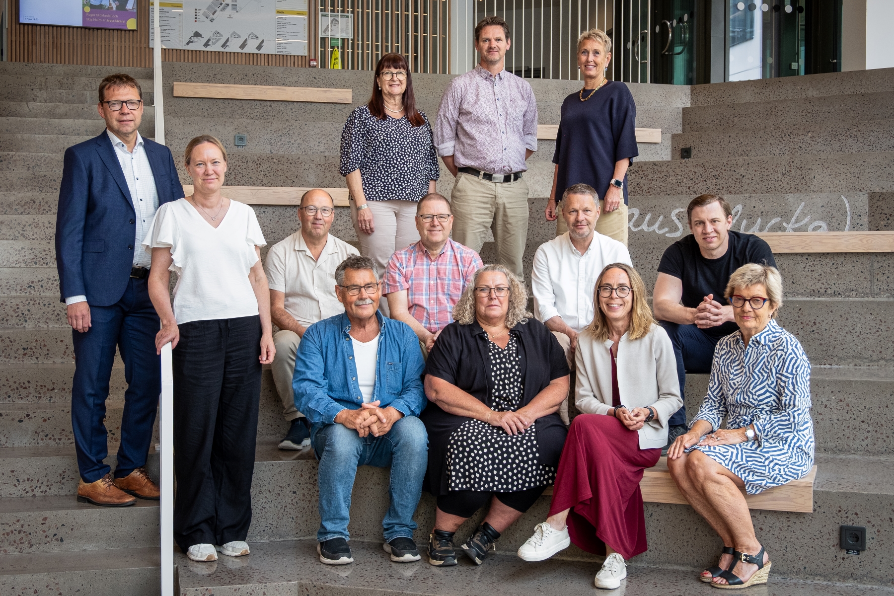 Gruppfoto av Kalmar Energi Holdings styrelse, bestående av 13 personer uppställda i tre rader på en trappa. Bilden är tagen inomhus i en trappa på Linnéuniversitetet i Kalmar.