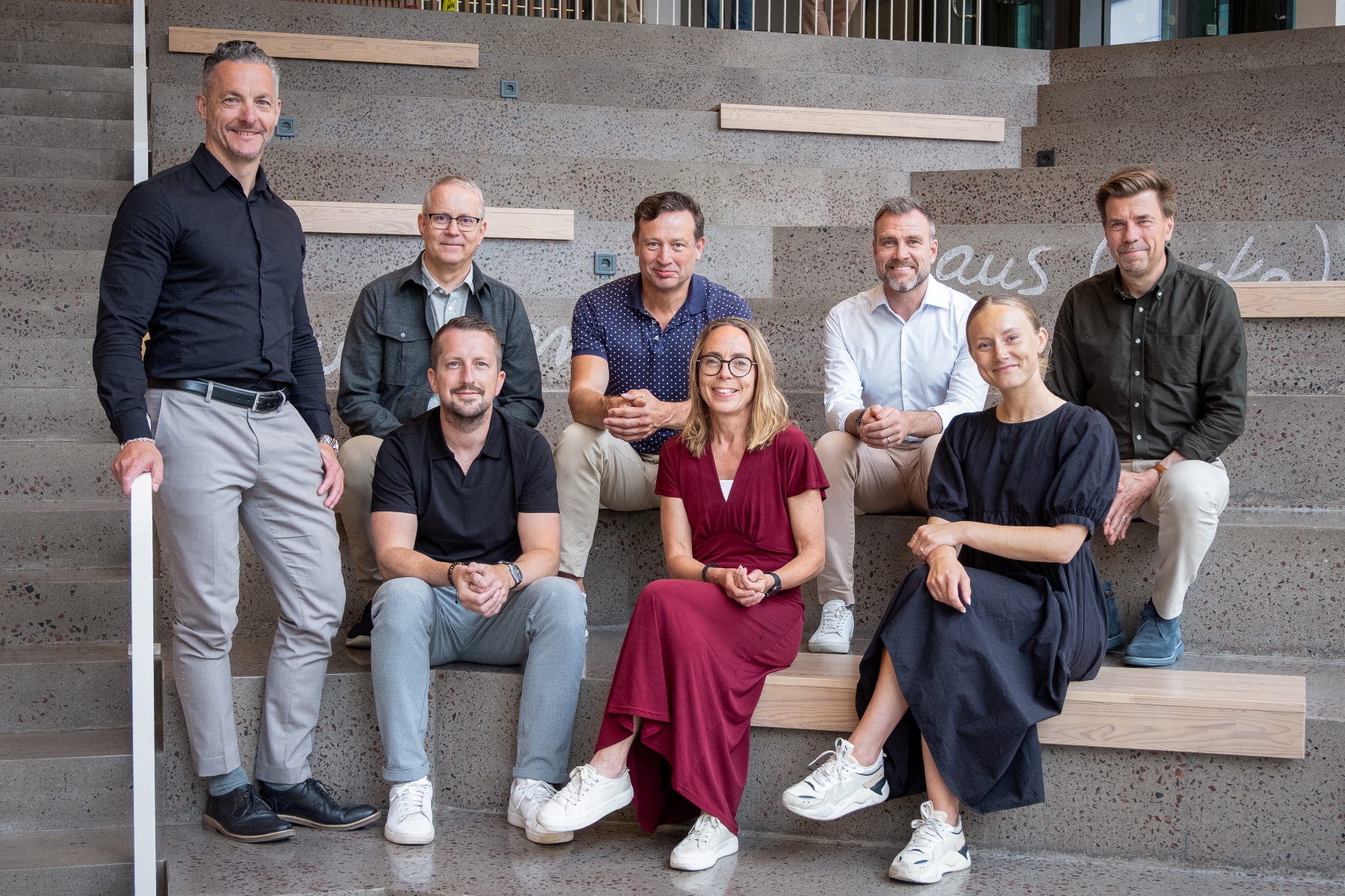 Gruppfoto av Kalmar Energi Holdings ledningsgrupp, bestående av åtta personer uppställda i tre rader på en trappa. Bilden är tagen inomhus i en trappa på Linnéuniversitetet i Kalmar.