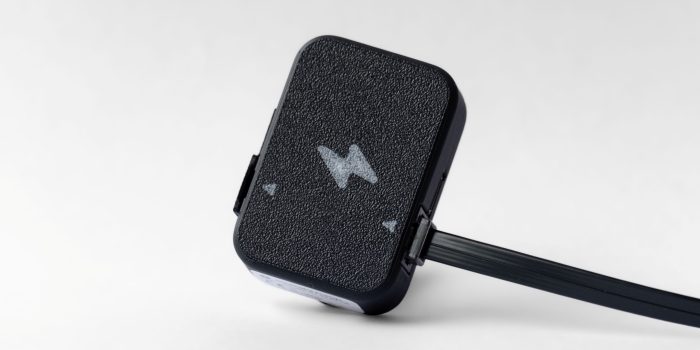 Realtidsmätare från Kalmar Energi fotograferad i studio på ljus bakgrund, med tydlig textur och svart kabel synlig på sidan.