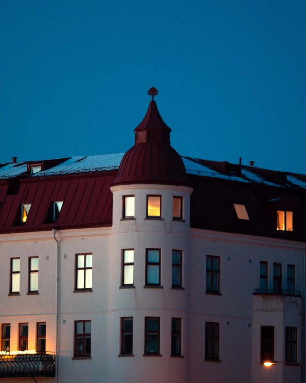 Flerbostadshus på Bremerlyckan i Kalmar en vinterkväll med upplysta fönster mot en blå himmel.