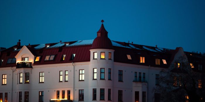 Flerbostadshus på Bremerlyckan i Kalmar en vinterkväll med upplysta fönster mot en blå himmel.