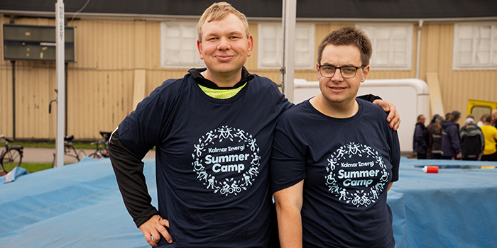 Två glada personer, klädda i t-shirts från Kalmar Energi som deltar på Summercamp 2026.